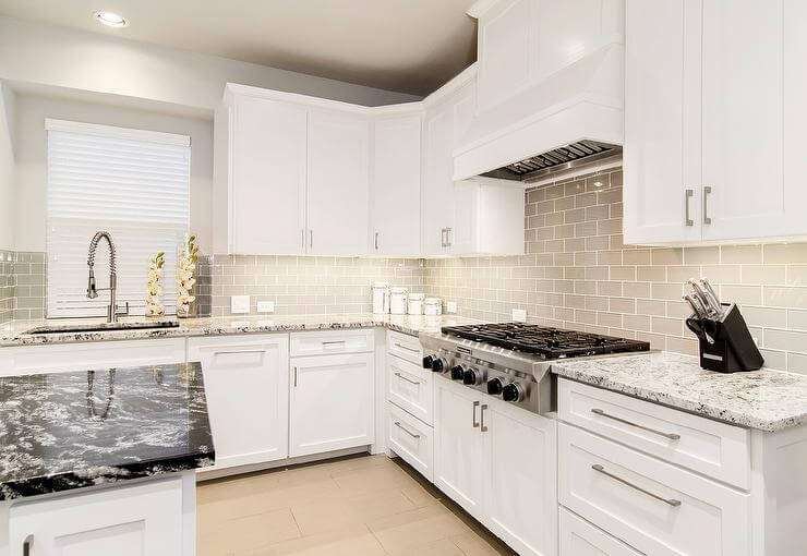 white-shaker-cabinets-gray-glass-subway-tile-backsplash-taupe-floor